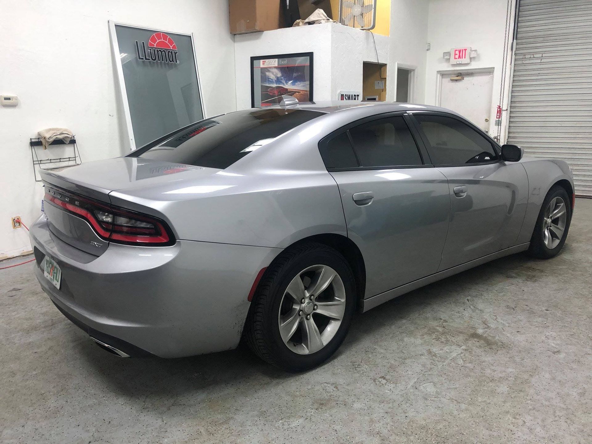 Silver sedan parked in a garage, rear three-quarter view.