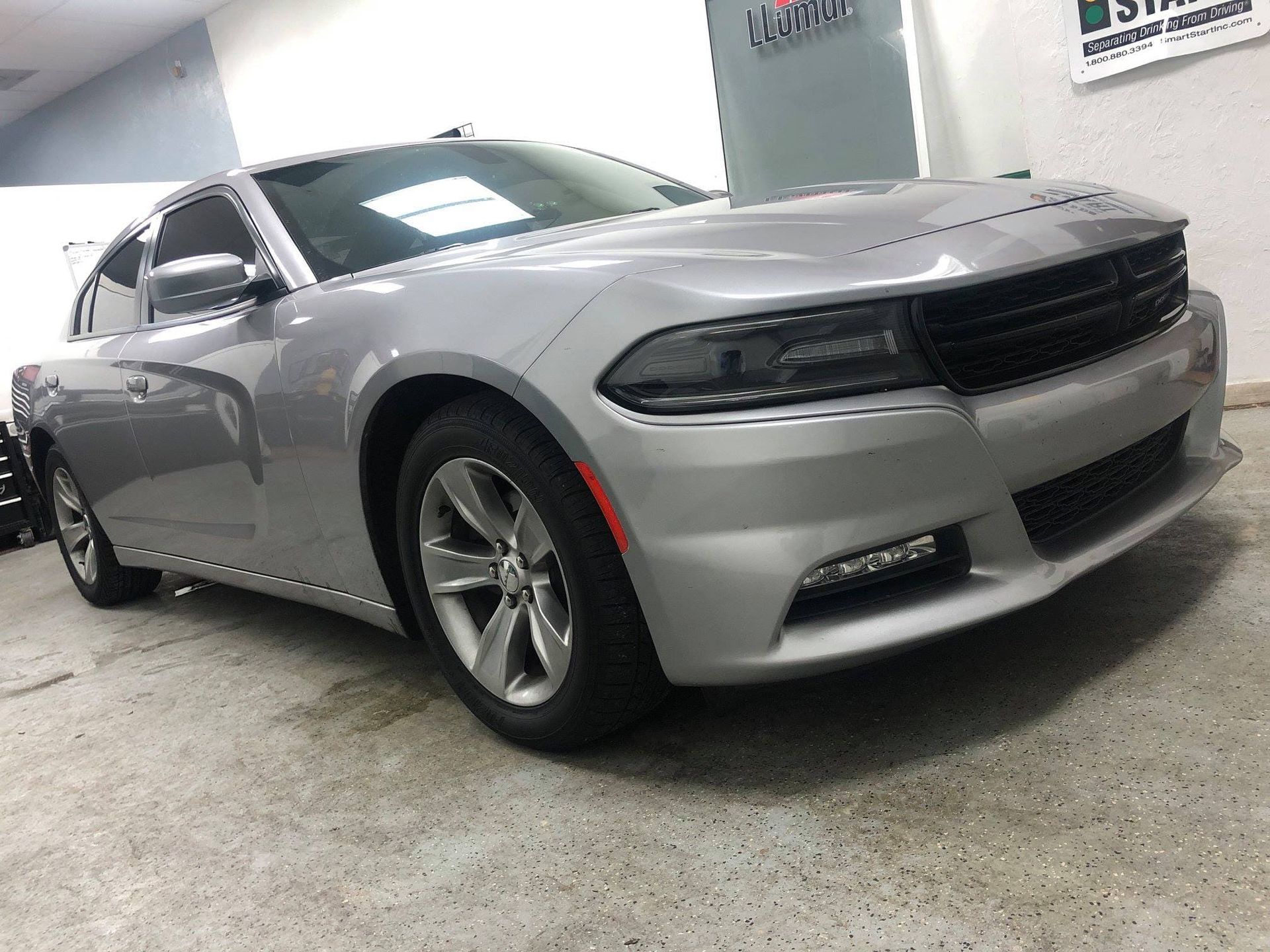 Silver Dodge Charger in a showroom, front-left view