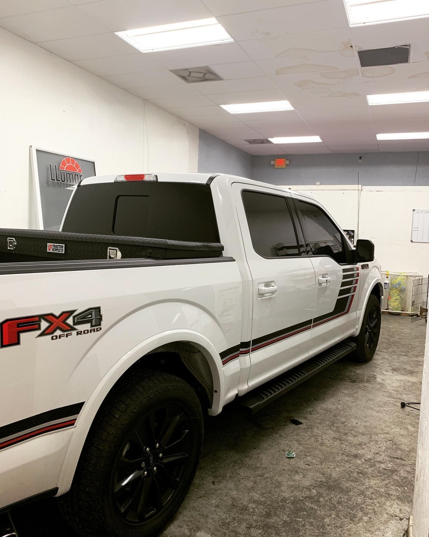 White Ford F-150 FX4 truck parked indoors under fluorescent lights