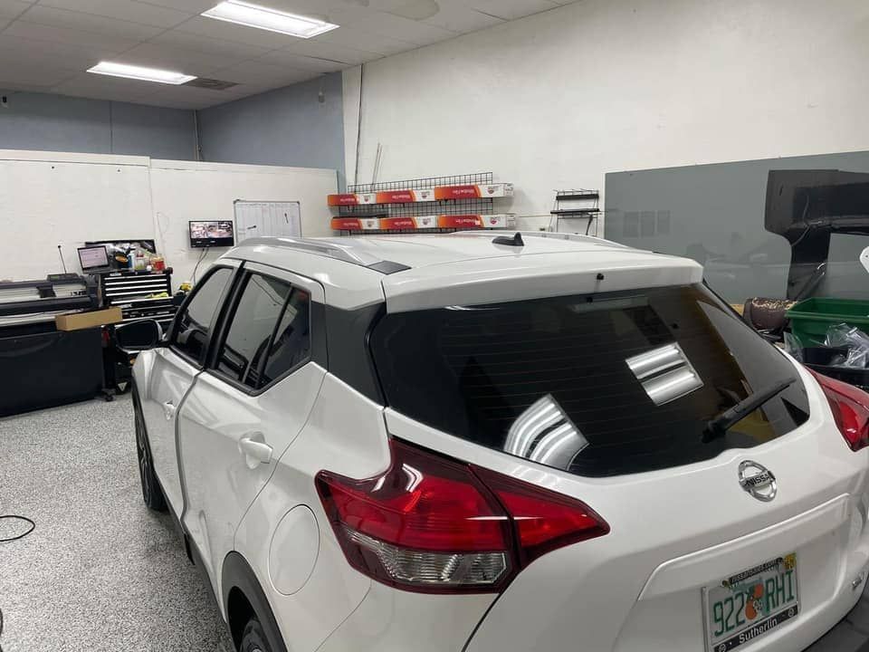 White SUV parked in a garage with shelves and tools in the background
