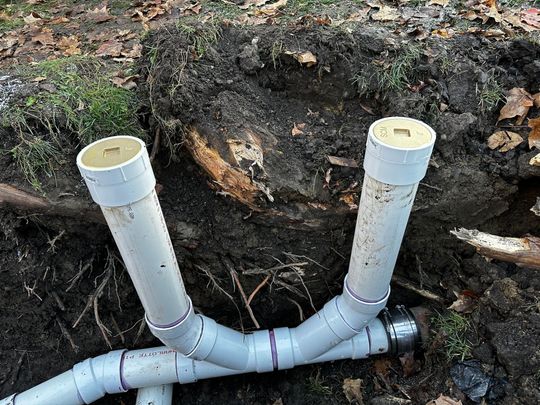 A pipe is being installed in a hole in the ground.
