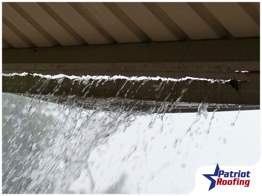 A patriot roofing logo can be seen on a gutter