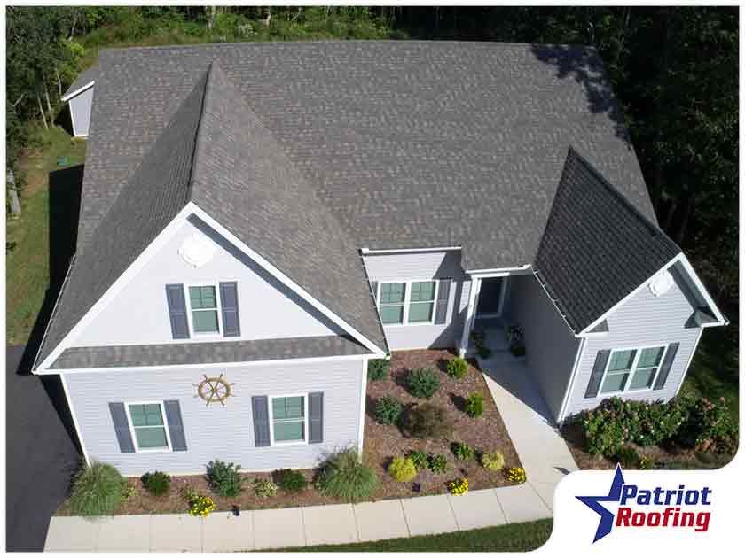 An aerial view of a house with a patriot roofing logo