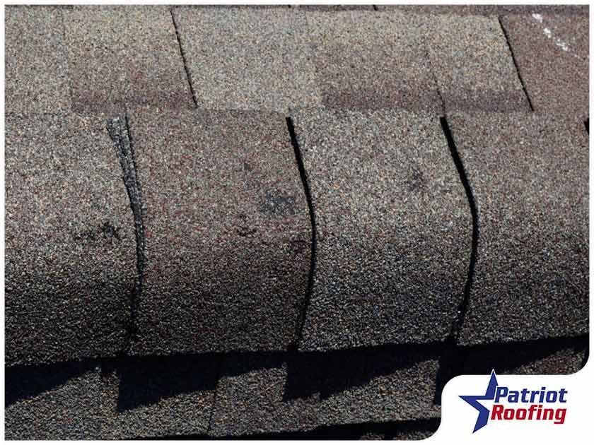 A close up of a roof with a patriot roofing logo in the corner