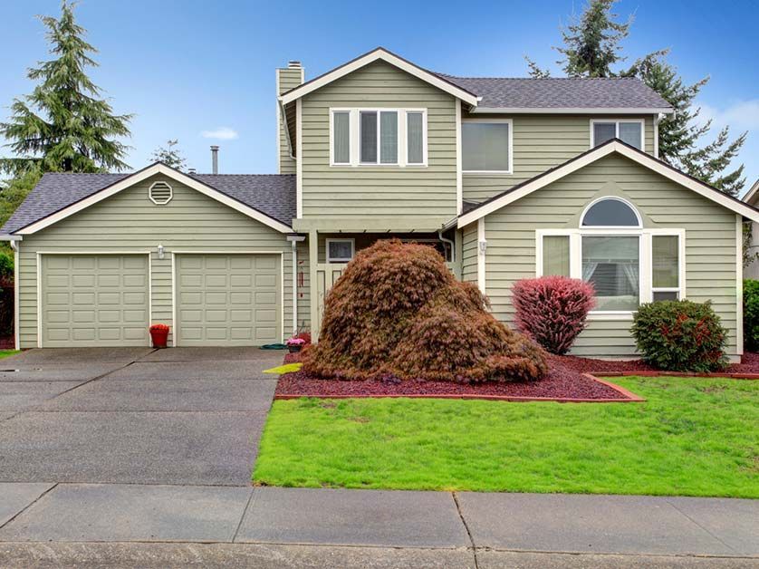 A house with a large pile of hay in front of it