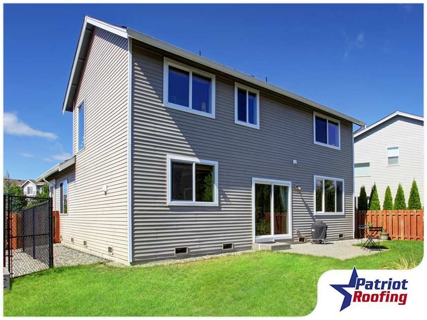 The back of a house with a patriot roofing logo in the corner