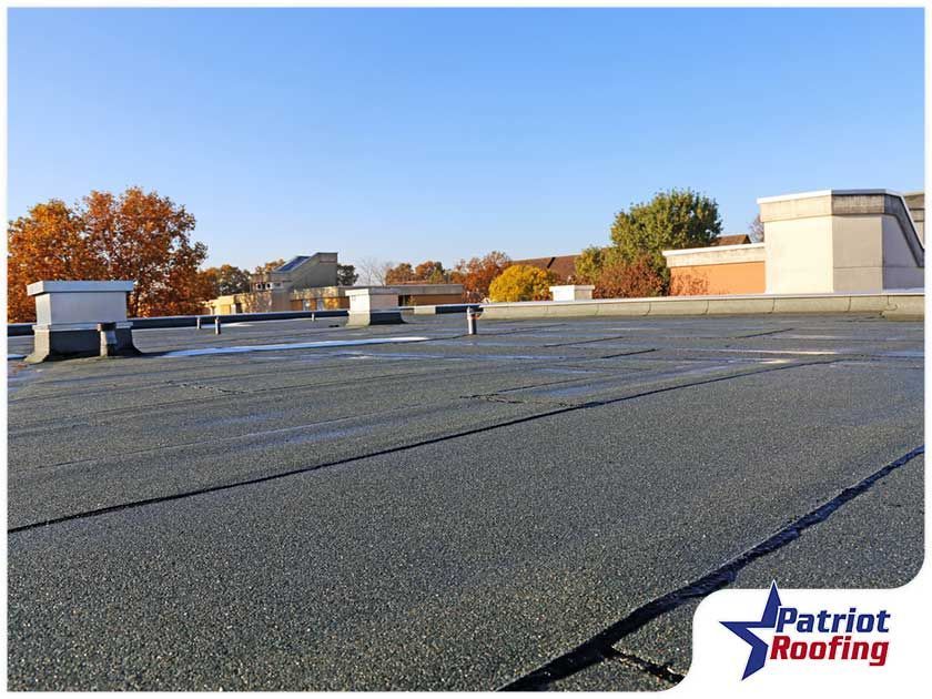 A picture of a roof with a patriot roofing logo in the corner