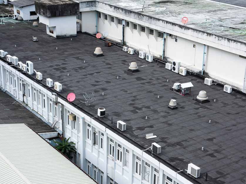The roof of a building with a lot of air conditioners on it.