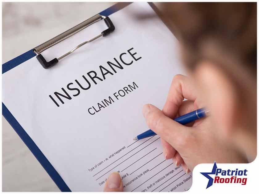 A person is filling out an insurance claim form on a clipboard.