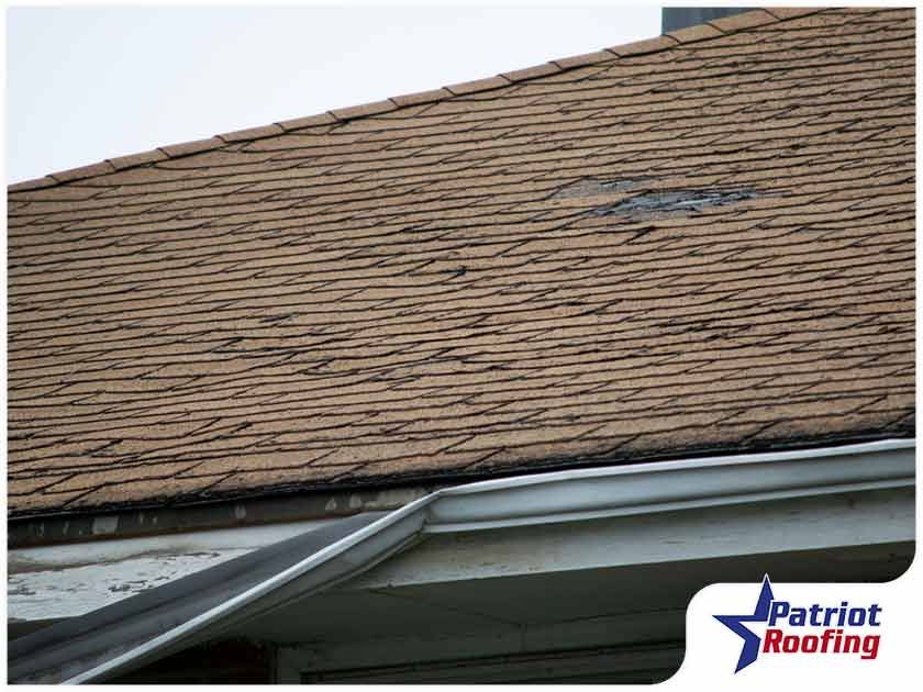 A picture of a roof with a patriot roofing logo in the corner