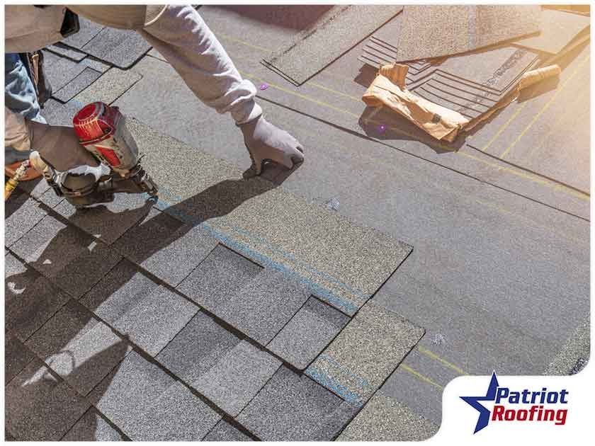 A person is installing shingles on a roof.