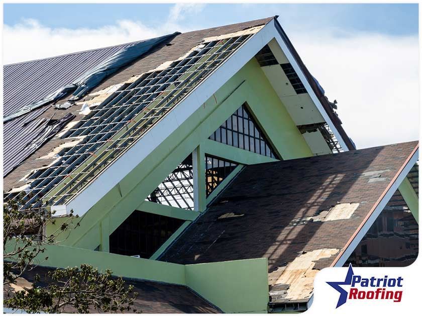 The roof of a building is being repaired by patriot roofing