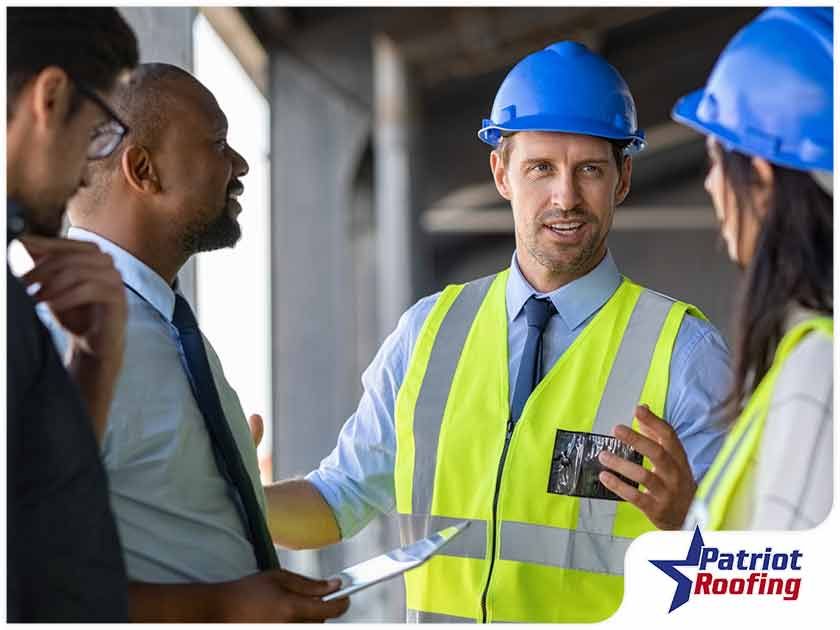A man in a hard hat is talking to a group of people.