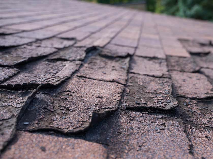 A close up of a roof with a lot of shingles missing.