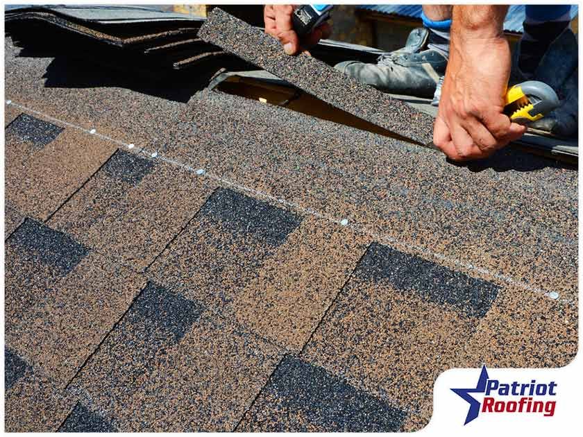 A man is cutting shingles on a roof with a pair of scissors.