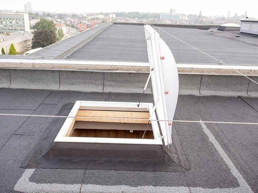 An open skylight on the roof of a building