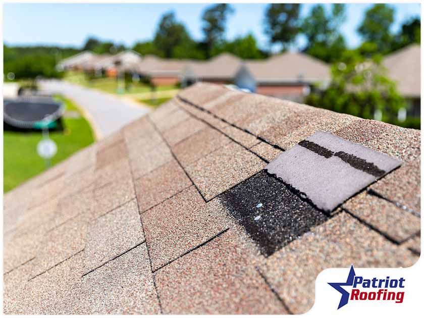 A picture of a roof with a patriot roofing logo in the corner