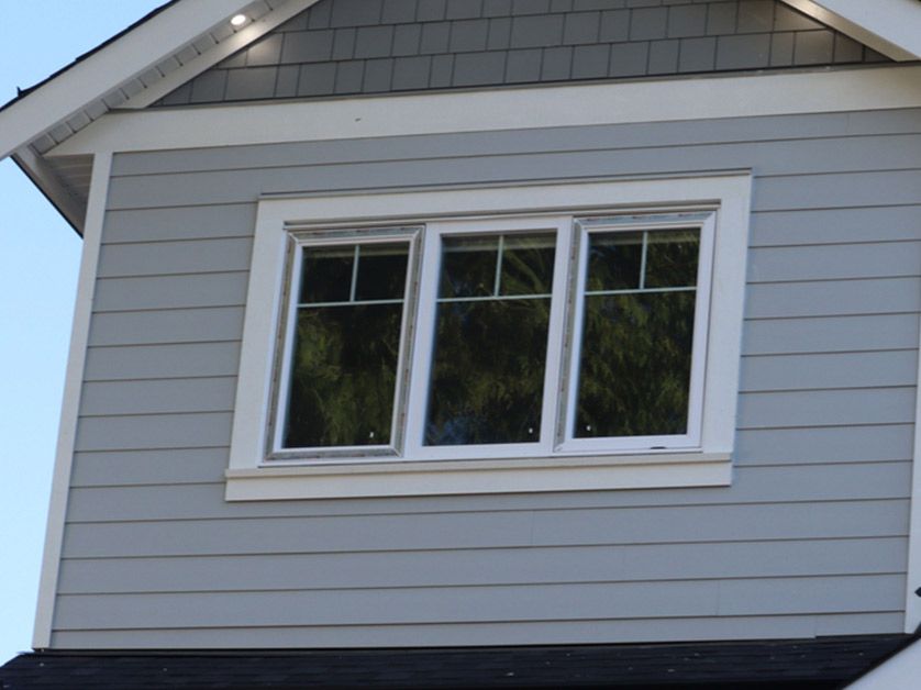 A house with three windows on the side of it