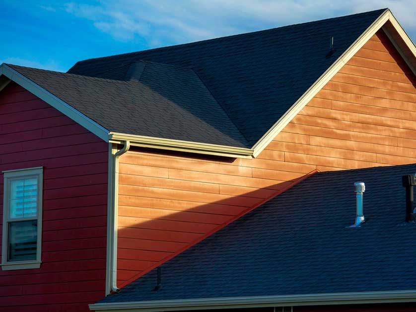 A red house with a black roof and a window