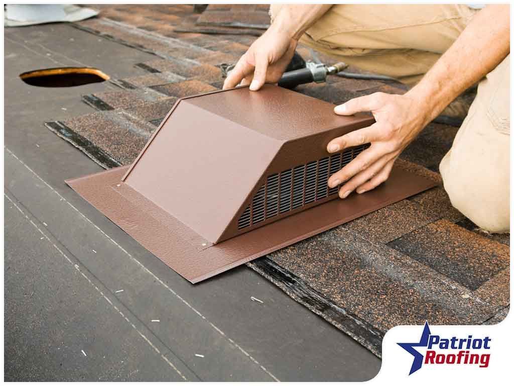 A man is installing a vent on a roof.