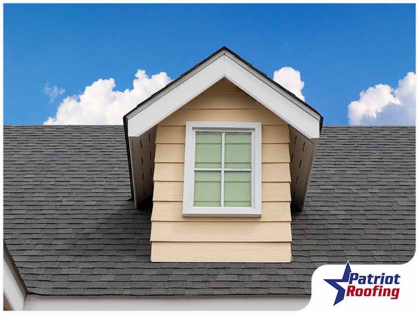 A picture of a roof with a window and the words patriot roofing on the bottom