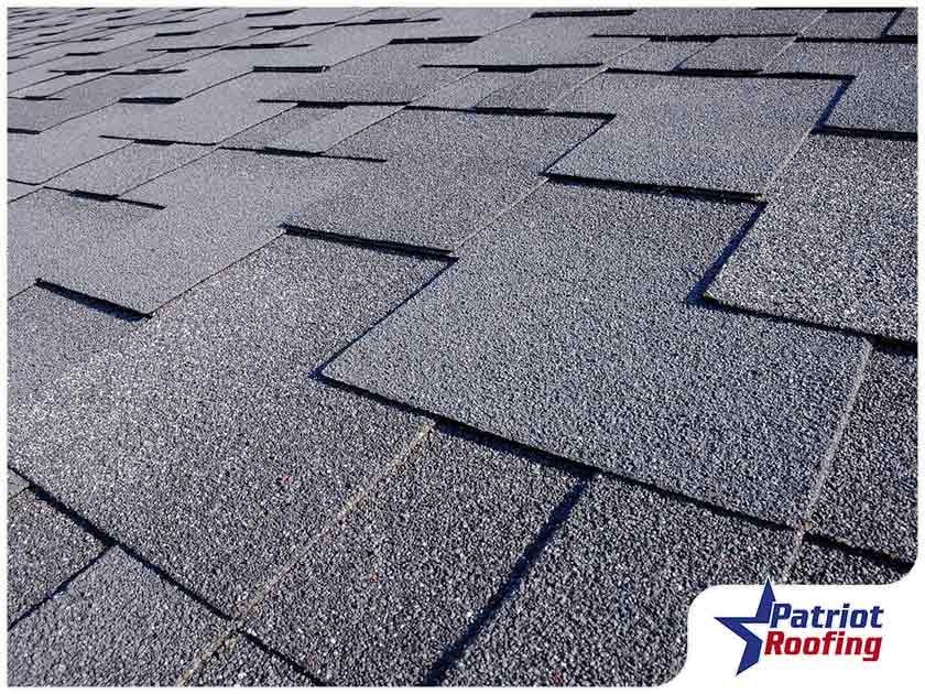 A close up of a roof with patriot roofing written on the bottom