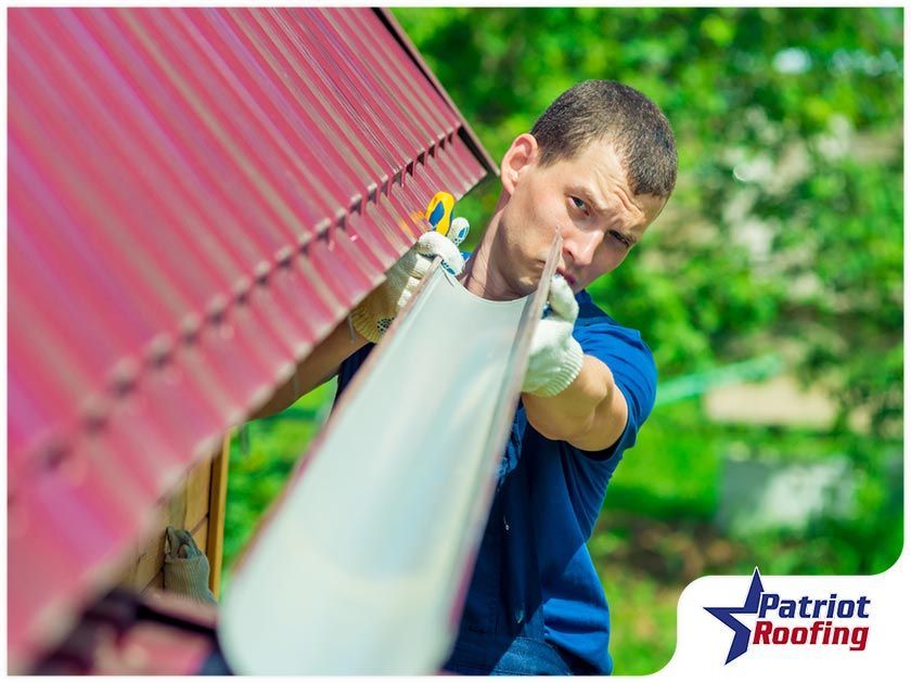 A man is installing a gutter on a roof.