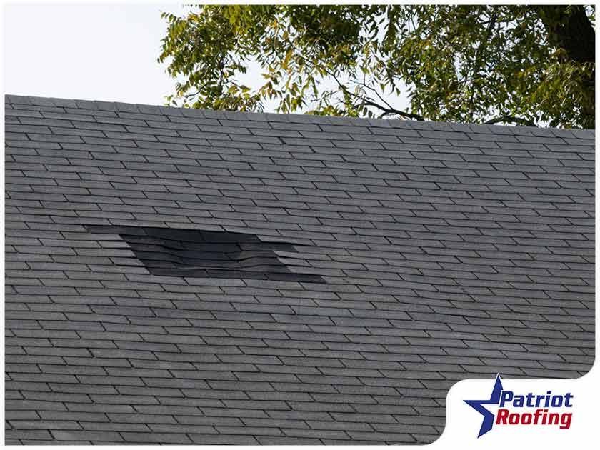 A roof with a hole in it and the words patriot roofing on the bottom