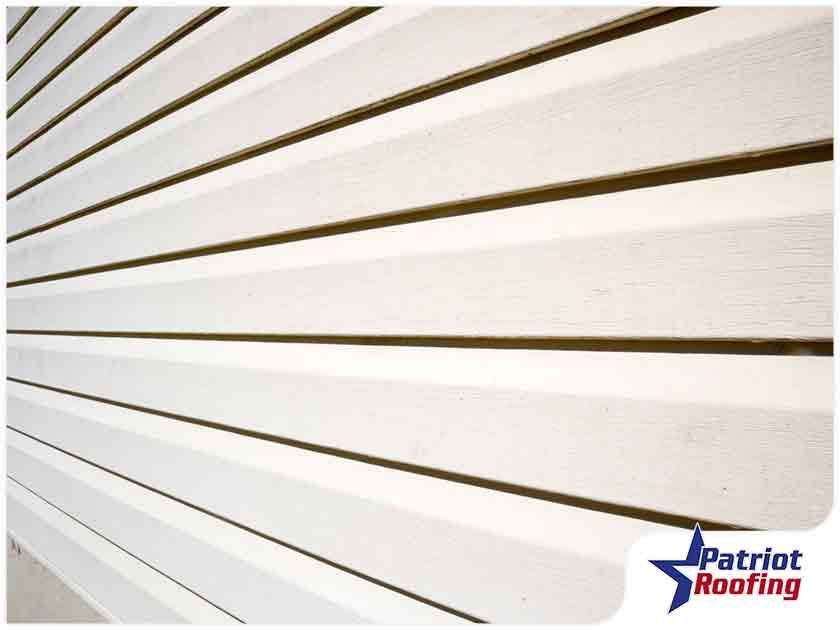 A picture of a white siding from patriot roofing