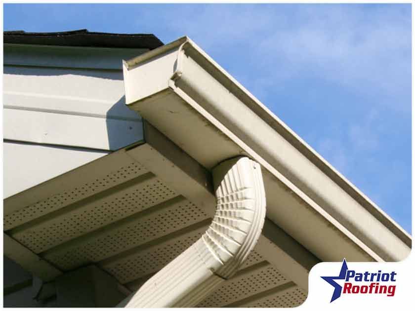 A picture of a gutter with patriot roofing in the corner
