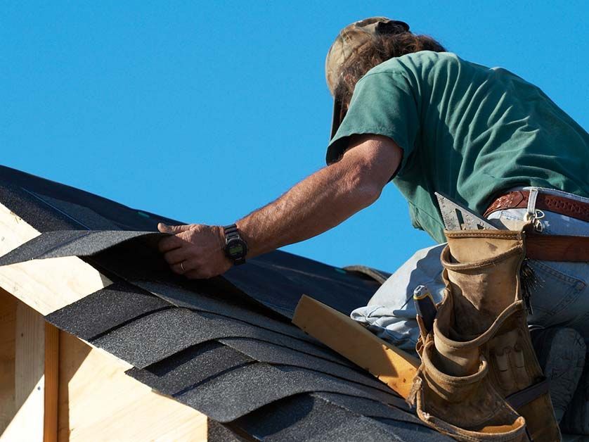 A man is working on the roof of a building