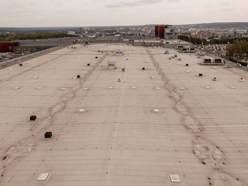 An aerial view of a large roof with a city in the background.