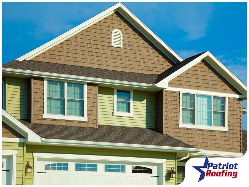 A house with a patriot roofing logo on it