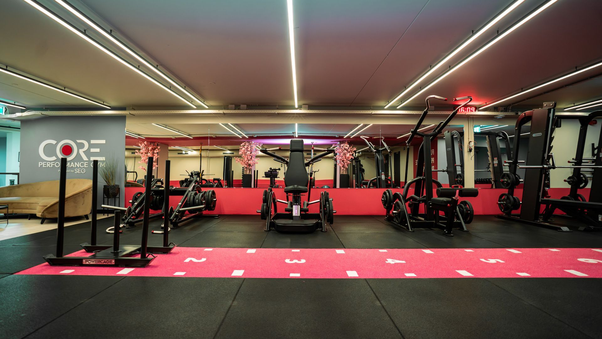 Een persoon doet een zittende core-oefening in een sportschool, terwijl hij een gewichtsschijf vasthoudt.