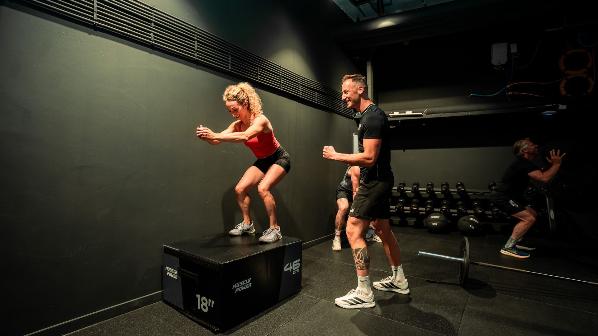 Zwarte gewichtsblokken op een fitnessapparaat met een gele selectiepin erin.