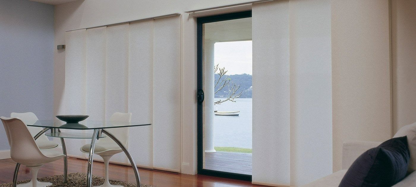 A Living Room With a Table and Chairs and a Sliding Glass Door — Simply Smarter Blinds in Nelson Bay, NSW
