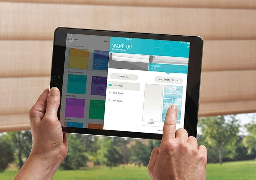 A Person is Holding a Tablet in Front of a Window — Simply Smarter Blinds in Medowie, NSW