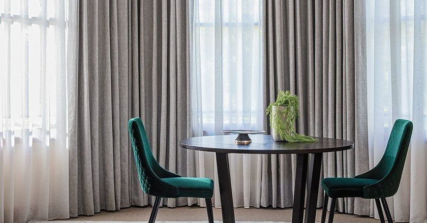 There is a Table and Chairs in the Room With Curtains — Simply Smarter Blinds in Corlette, NSW