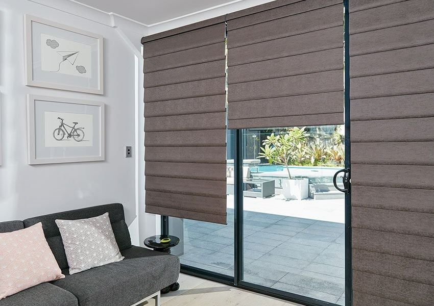 A Living Room With a Couch and Sliding Glass Doors With Roman Blinds — Simply Smarter Blinds in North Arm Cove, NSW