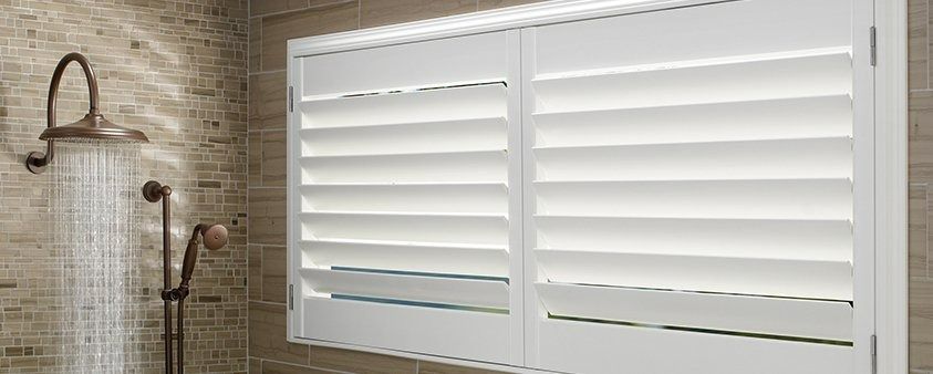 A Bathroom With a Shower and Shutters on the Window — Simply Smarter Blinds in Tea Gardens, NSW
