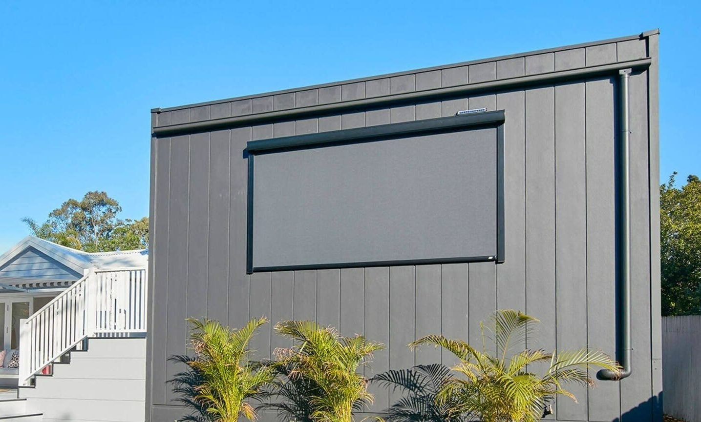A Gray Building With a Screen on the Side of It — Simply Smarter Blinds in Hawks Nest, NSW