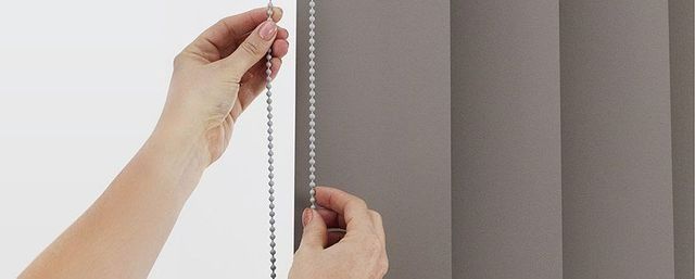 A Person is Pulling a Chain on a Vertical Blind — Simply Smarter Blinds in Hawks Nest, NSW