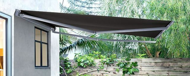 A Black Awning is Hanging From the Side of a House — Simply Smarter Blinds in Hawks Nest, NSW
