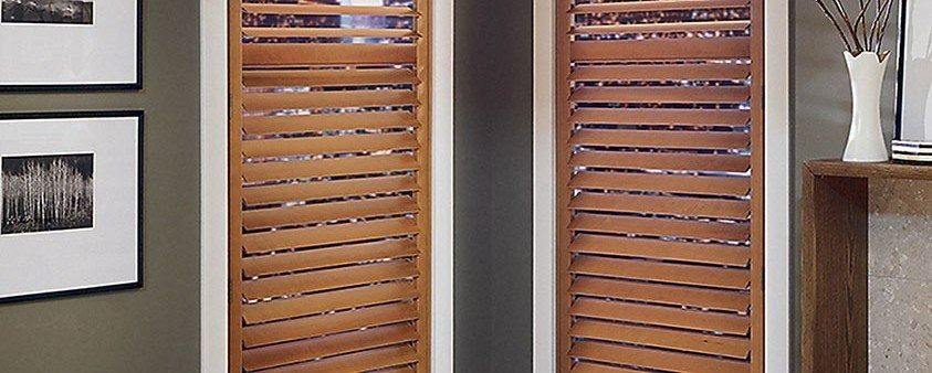 A Pair of Wooden Shutters in a Living Room — Simply Smarter Blinds in Hawks Nest, NSW