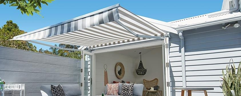A White House With a Striped Awning Over the Door — Simply Smarter Blinds in Soldiers Point, NSW
