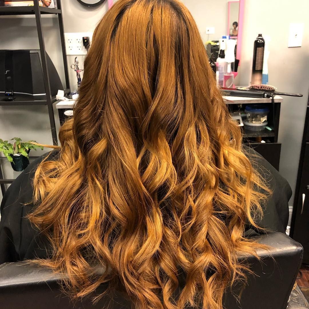 Wavy copper hair styled down, viewed from behind in a salon chair