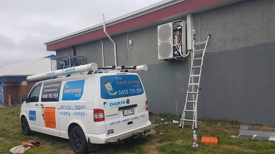 A White Van Is Parked in Front of A Building with A Ladder Attached to It- Hobart, TAS - The Heat Pump Man