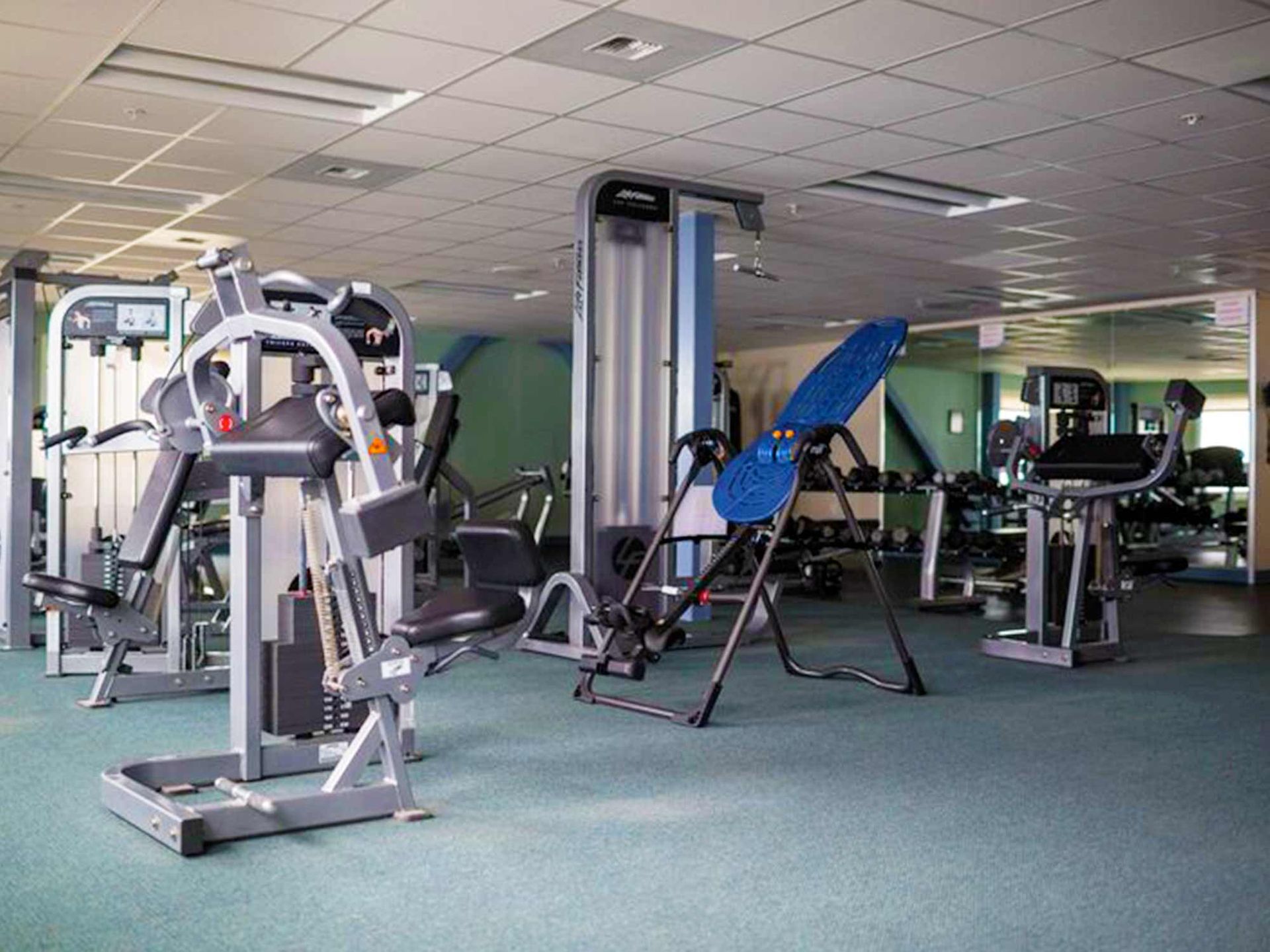 A large gym filled with lots of exercise equipment.