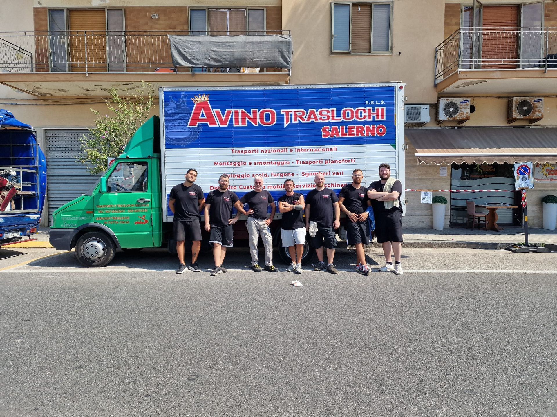 Gruppo di persone in posa accanto a un camioncino verde con una grande insegna 