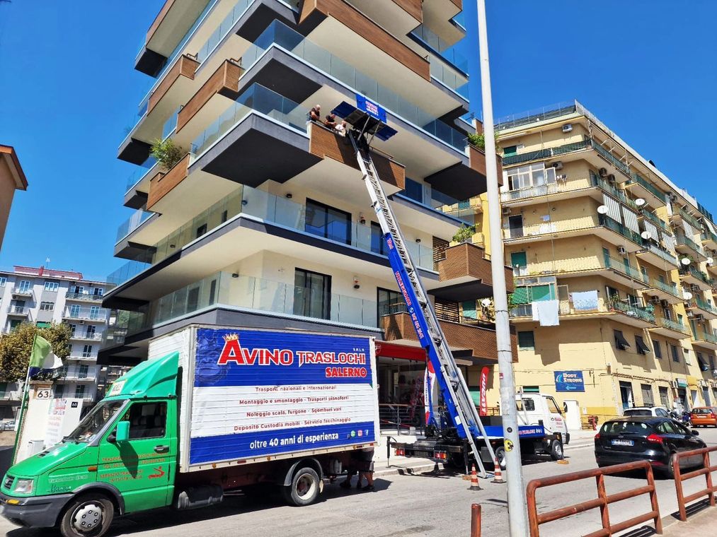 Camion per traslochi e scala accanto a un condominio a più piani in una strada cittadina